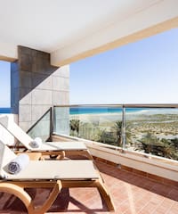 chairs on a balcony overlooking the ocean