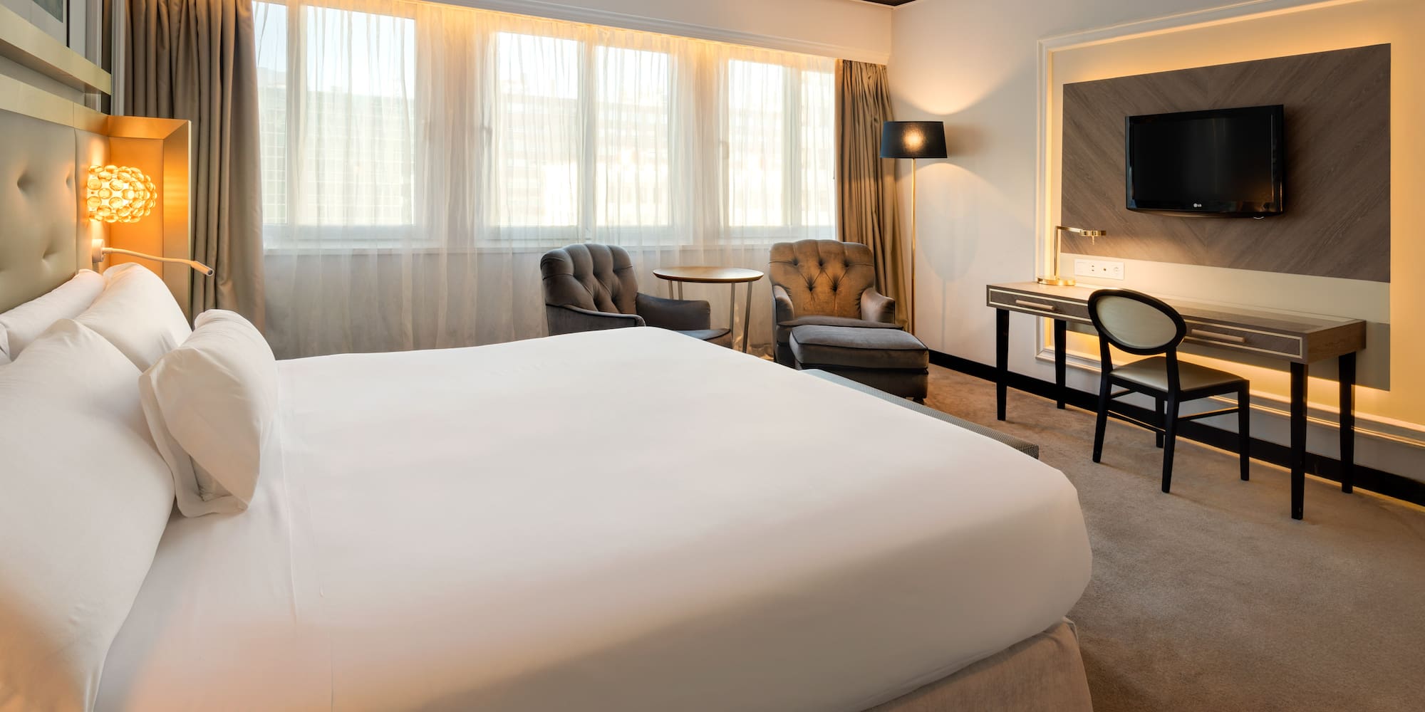 a hotel room with a bed and a desk