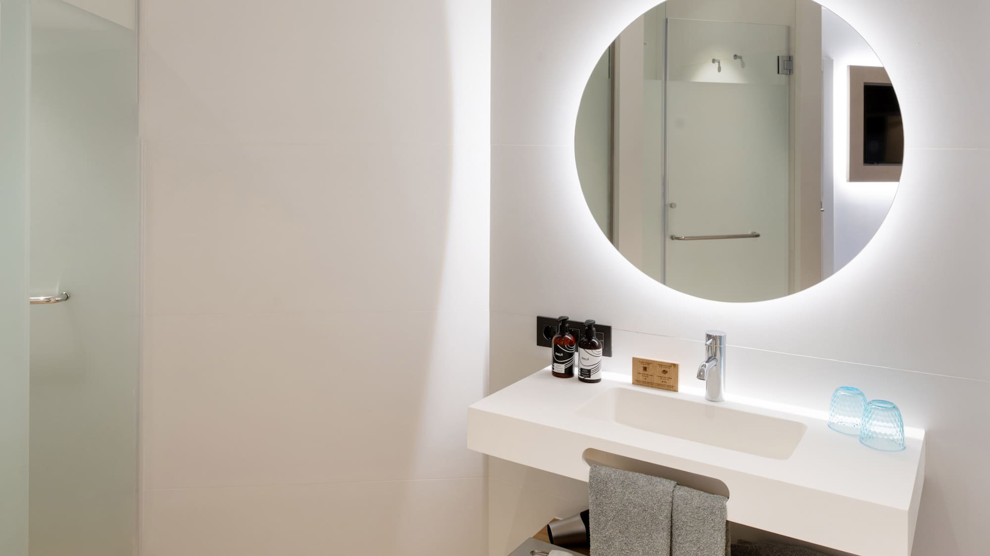a bathroom with a round mirror and a sink
