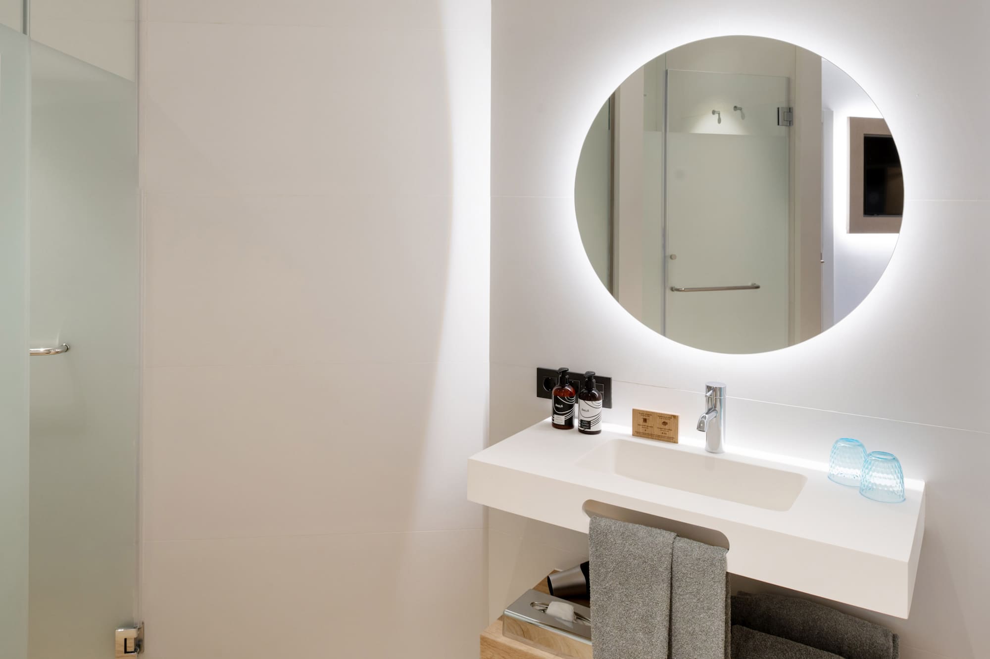 a bathroom with a round mirror and a sink