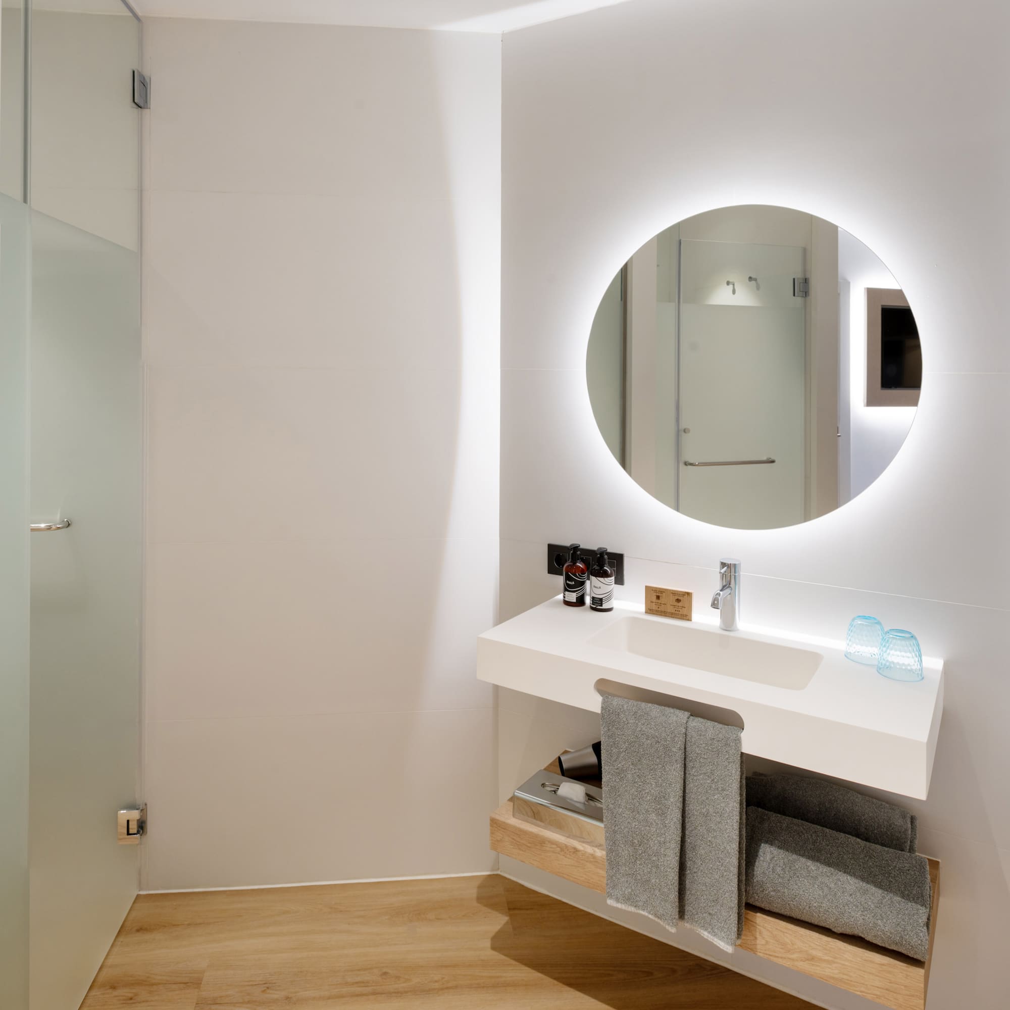 a bathroom with a round mirror and a sink