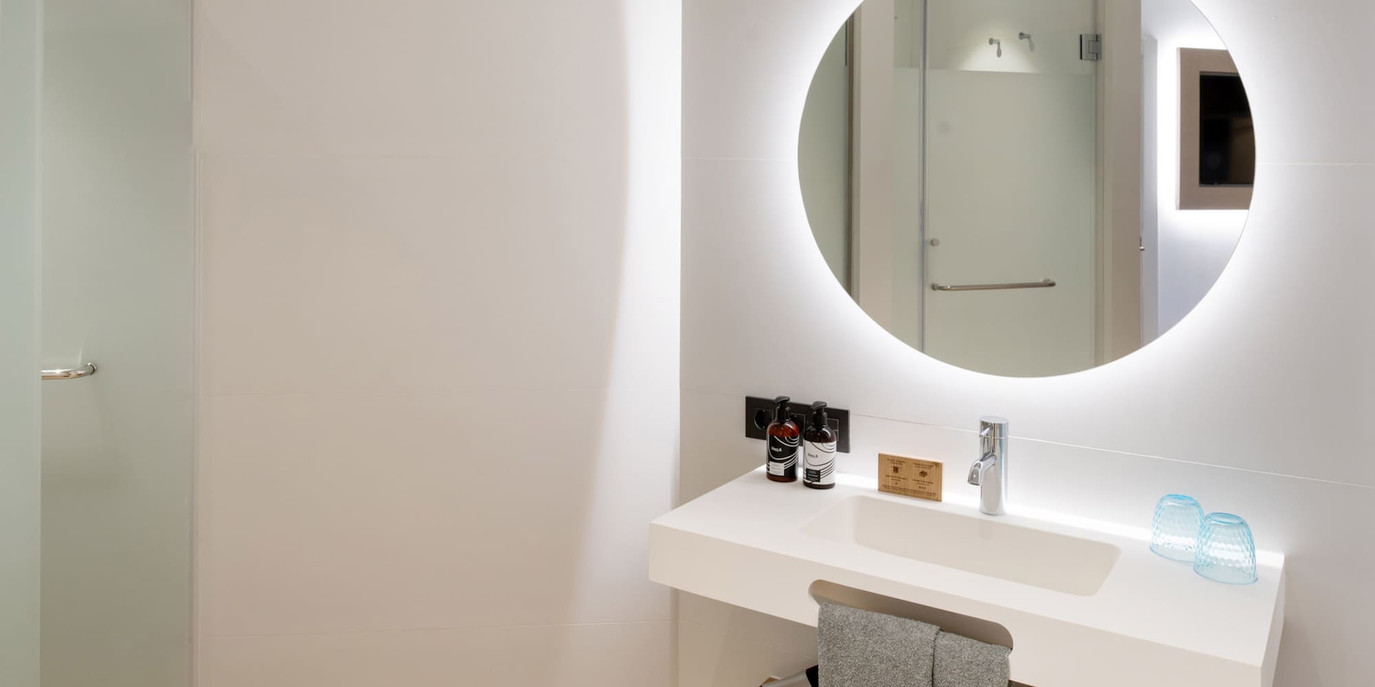 a bathroom with a round mirror and a sink