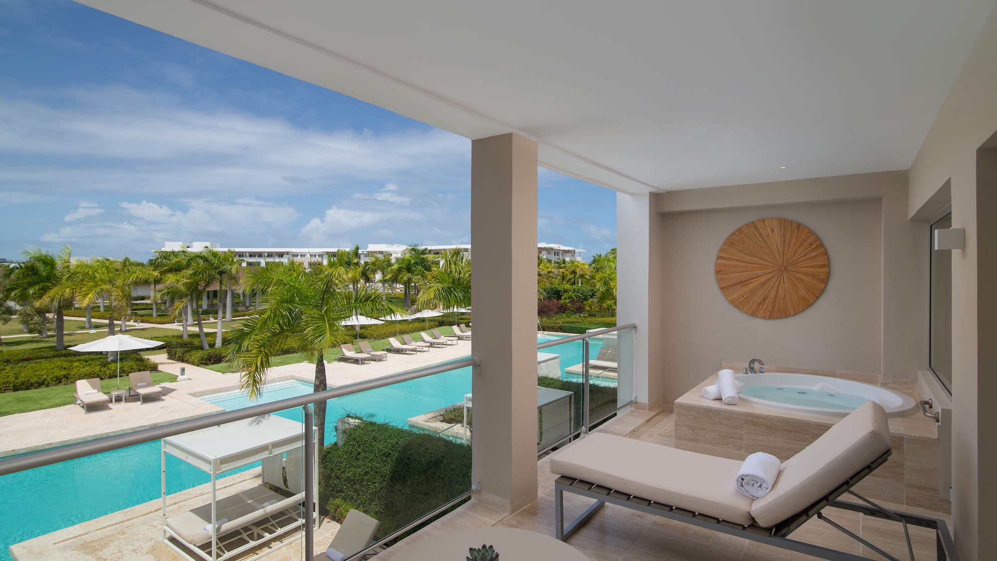 a balcony with a jacuzzi and a pool