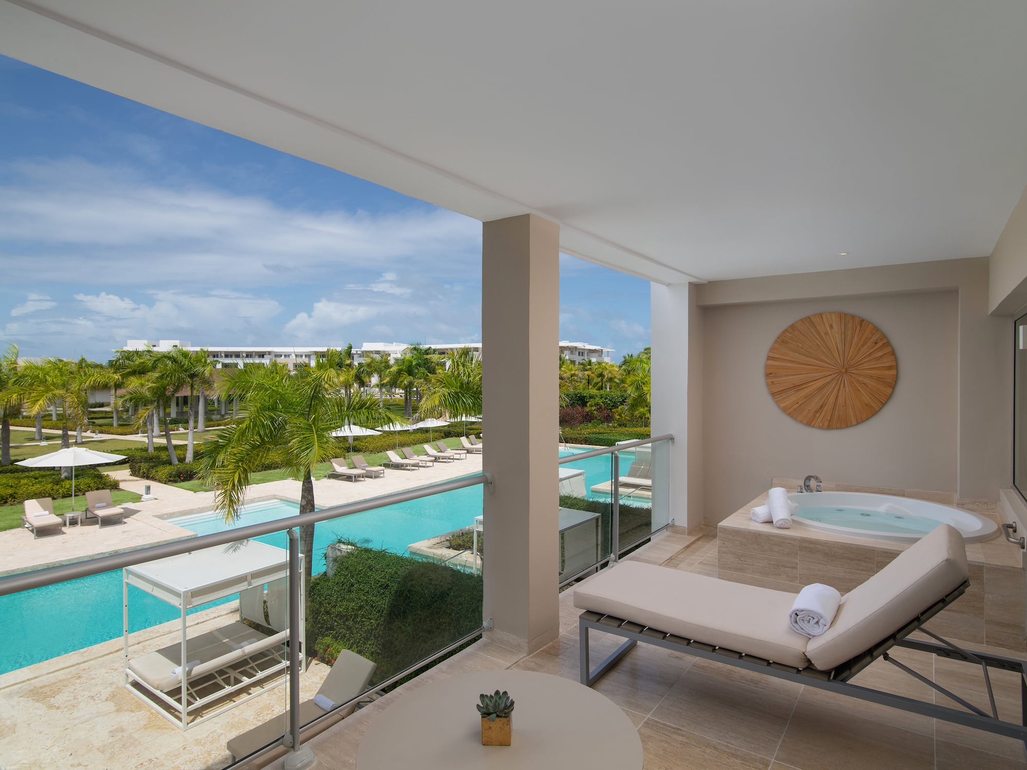 a balcony with a jacuzzi and a pool