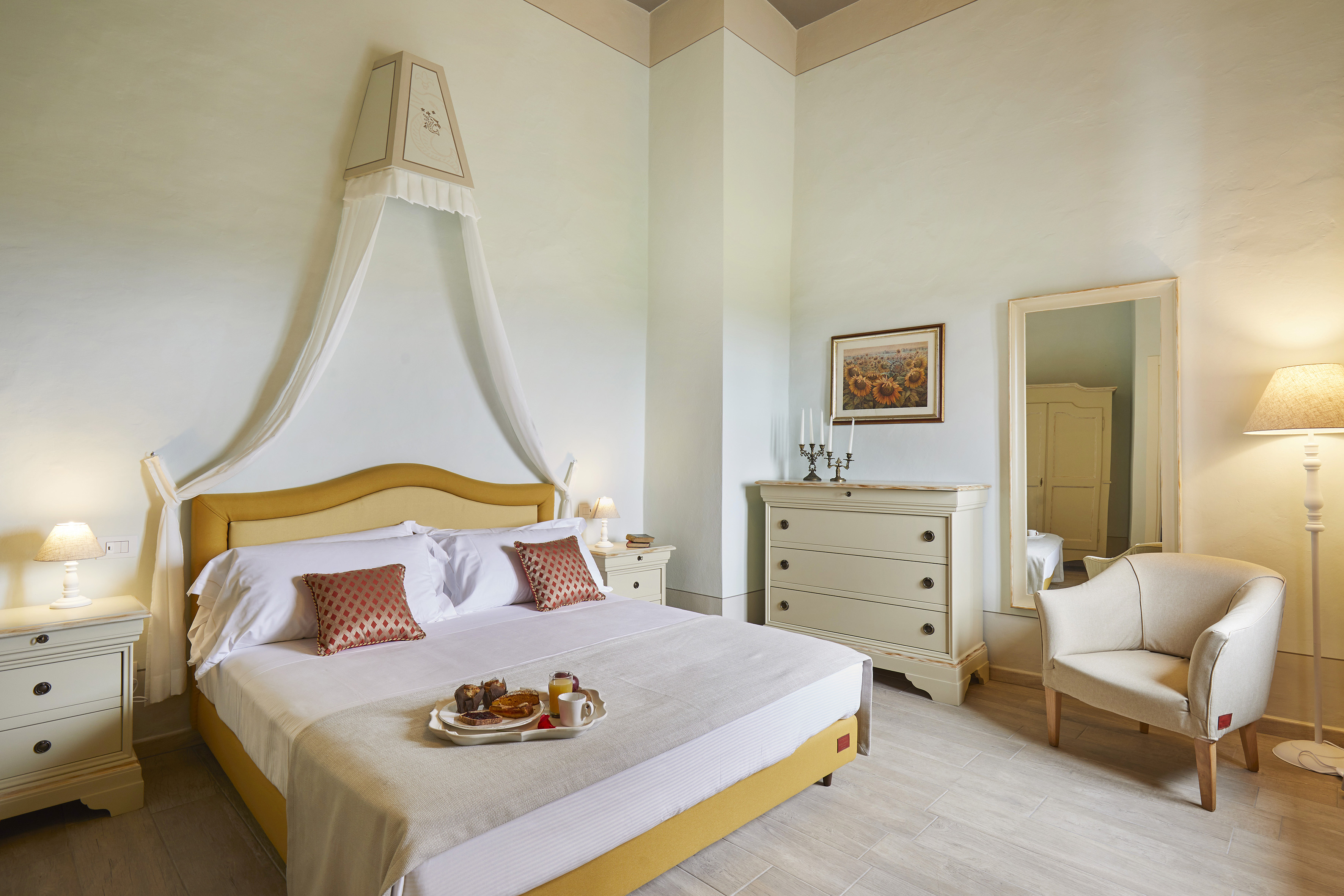 Hotel room with breakfast in bed, yellow bed, and elegant canopy.