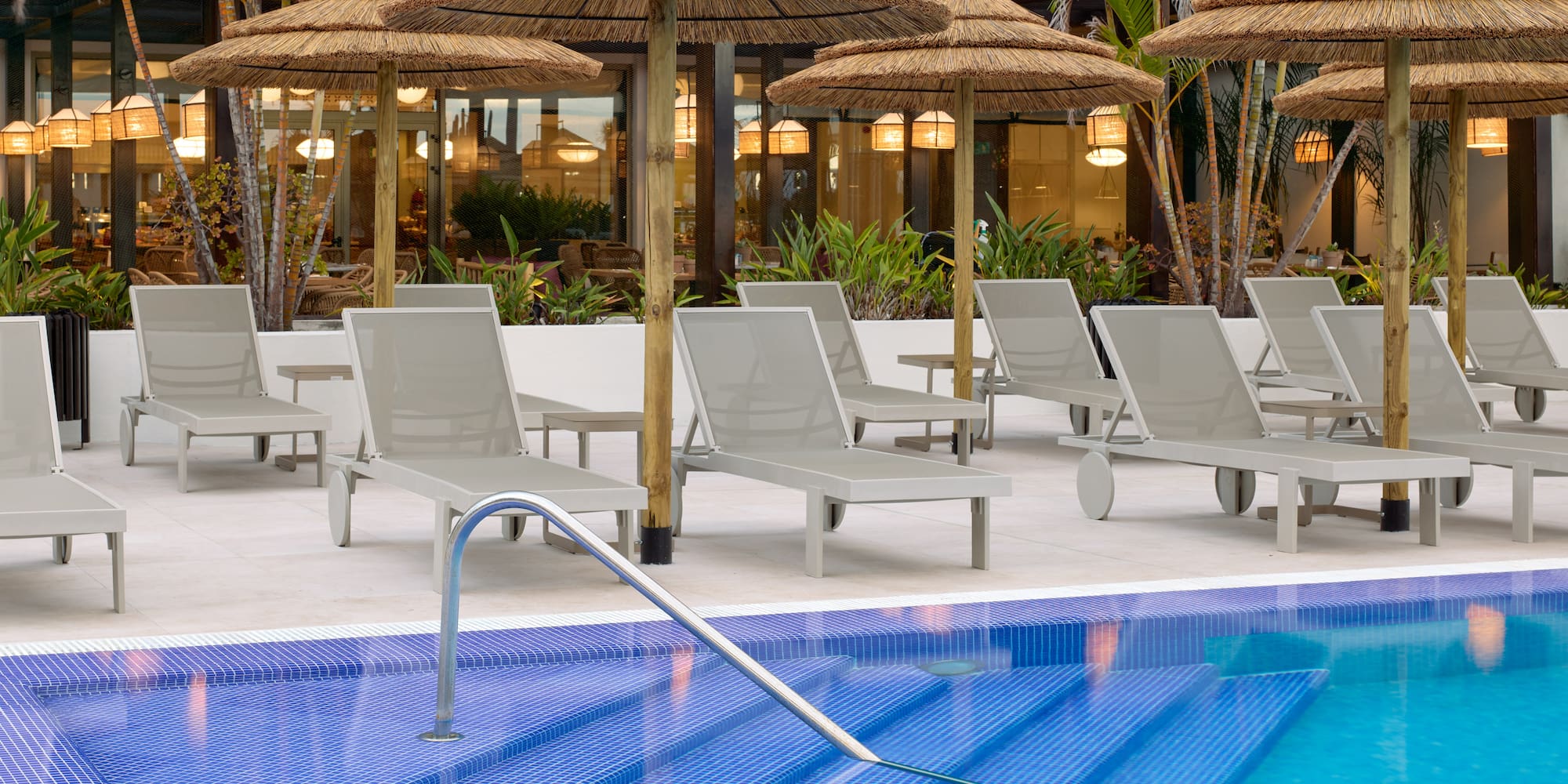 a pool with lounge chairs and umbrellas