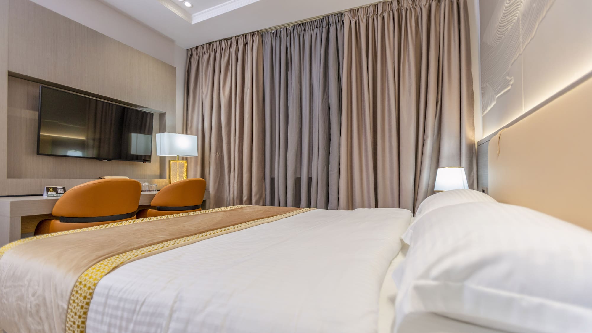 a bed with a lamp and a mirror in a room