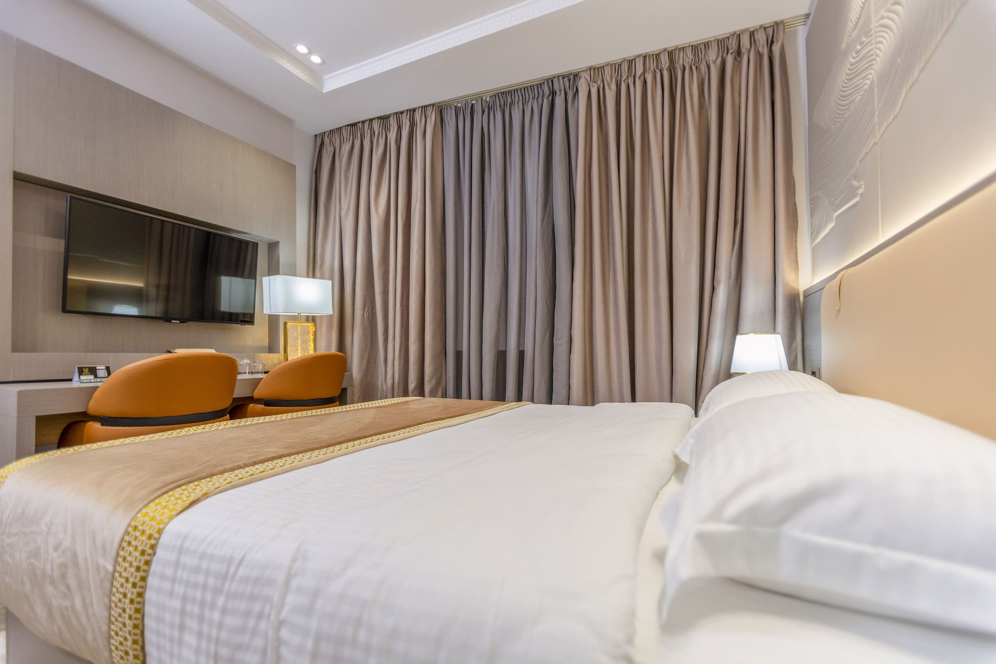 a bed with a lamp and a mirror in a room