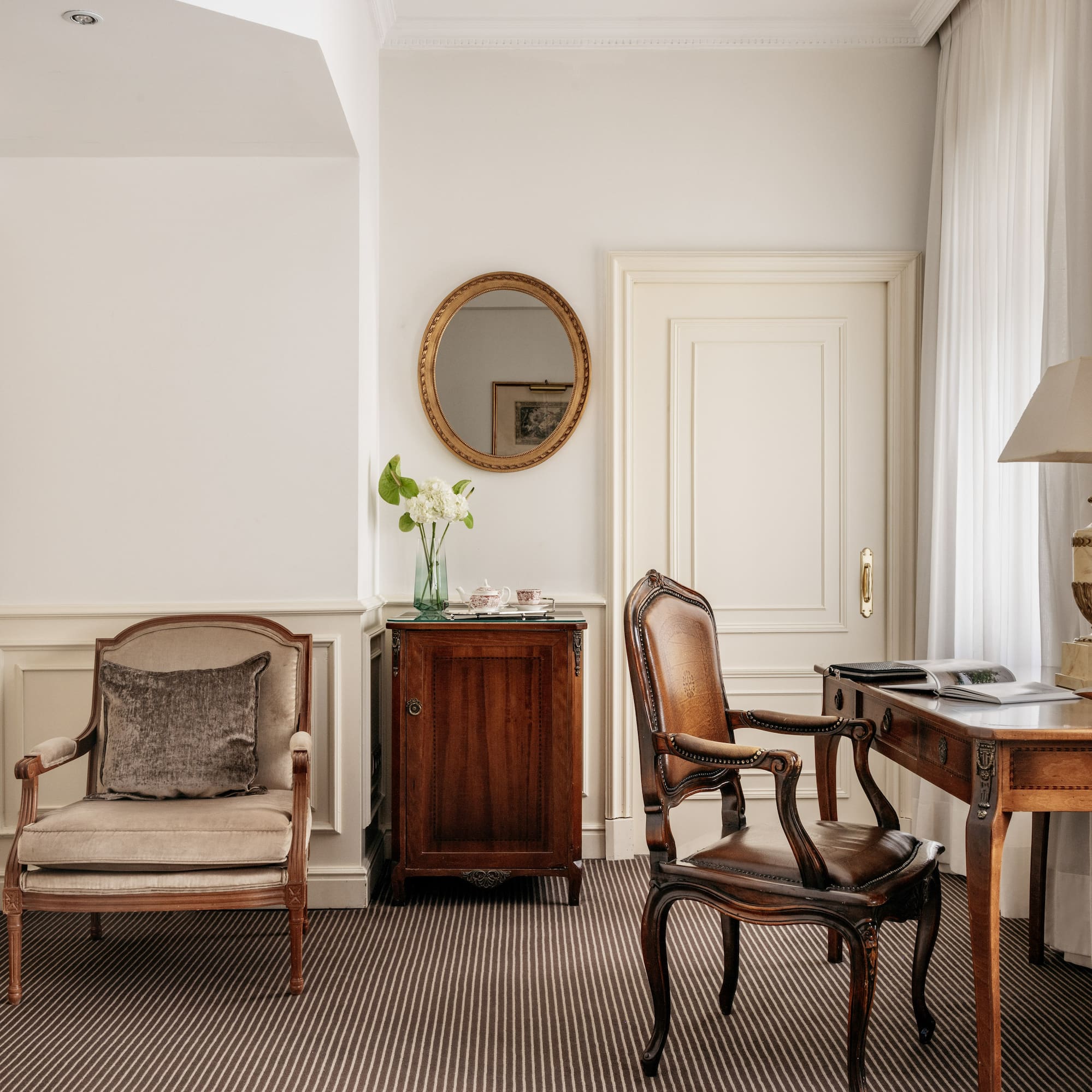 a room with a desk and chairs