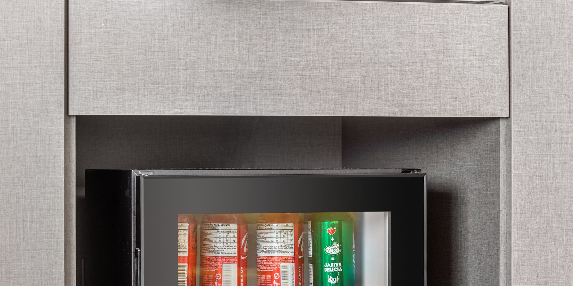 a small refrigerator with drinks and cups on top of it