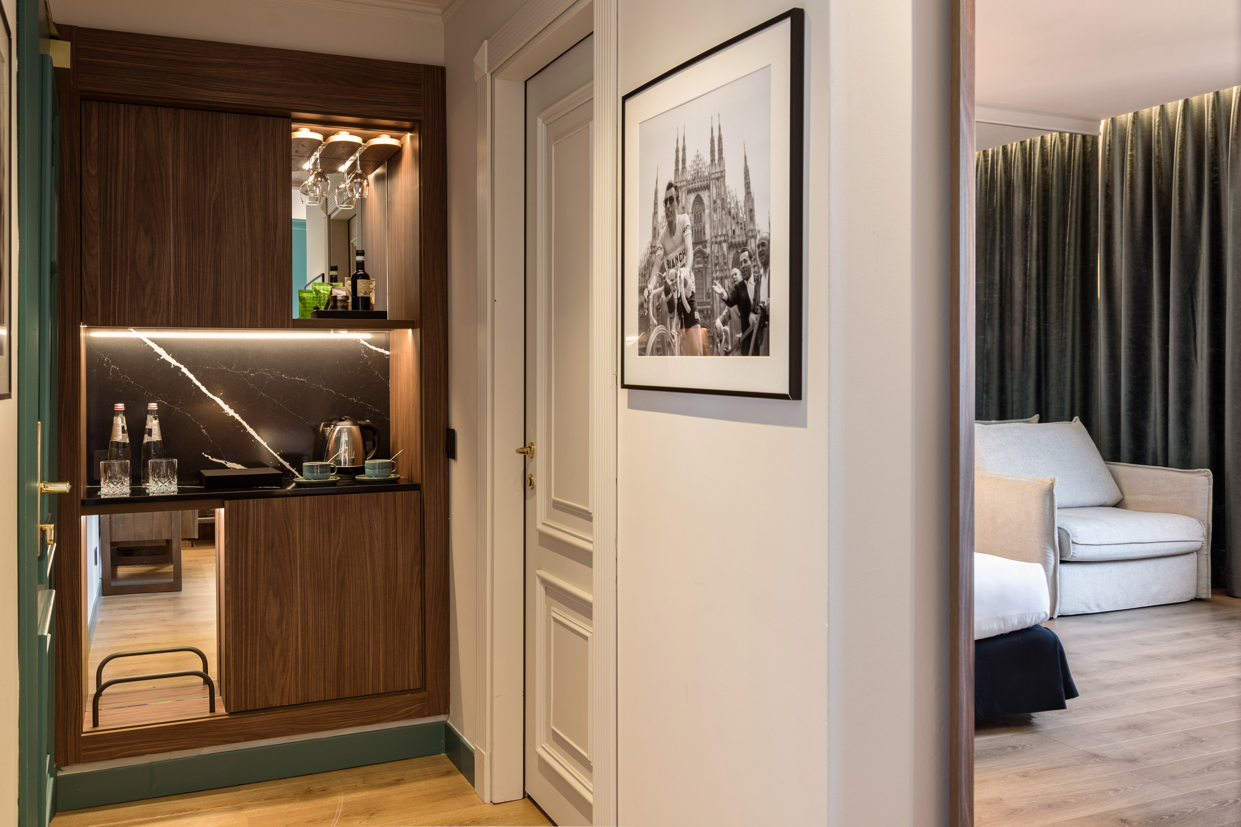 Luxury hotel minibar, black marble, under-cabinet lighting, cycling art.