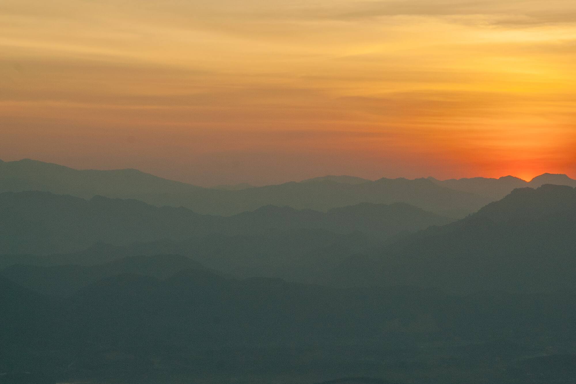 a sunset over a mountain range