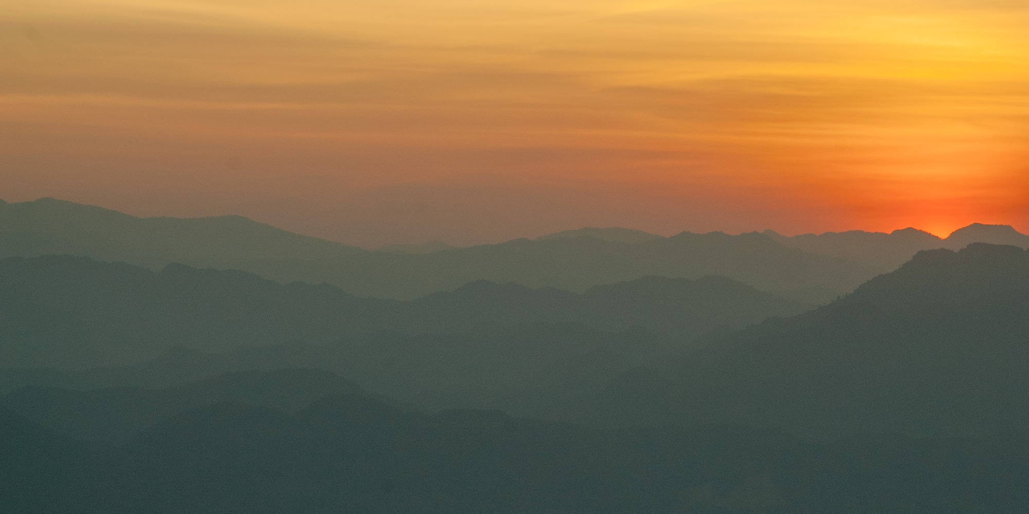 a sunset over a mountain range