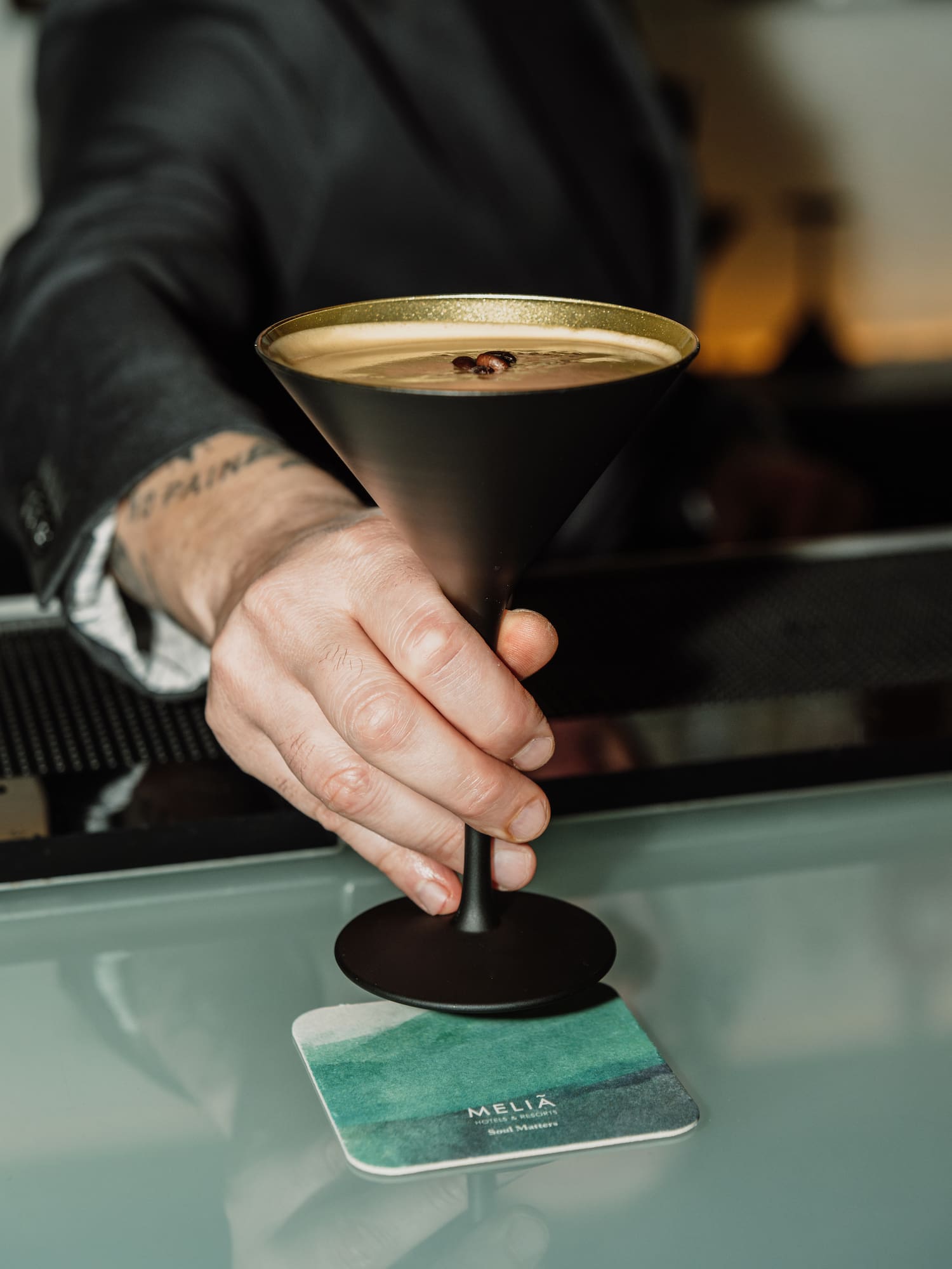 a hand holding a glass with liquid in it