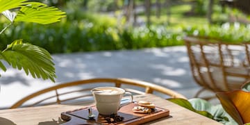 a cup of coffee and cookies on a wooden tray