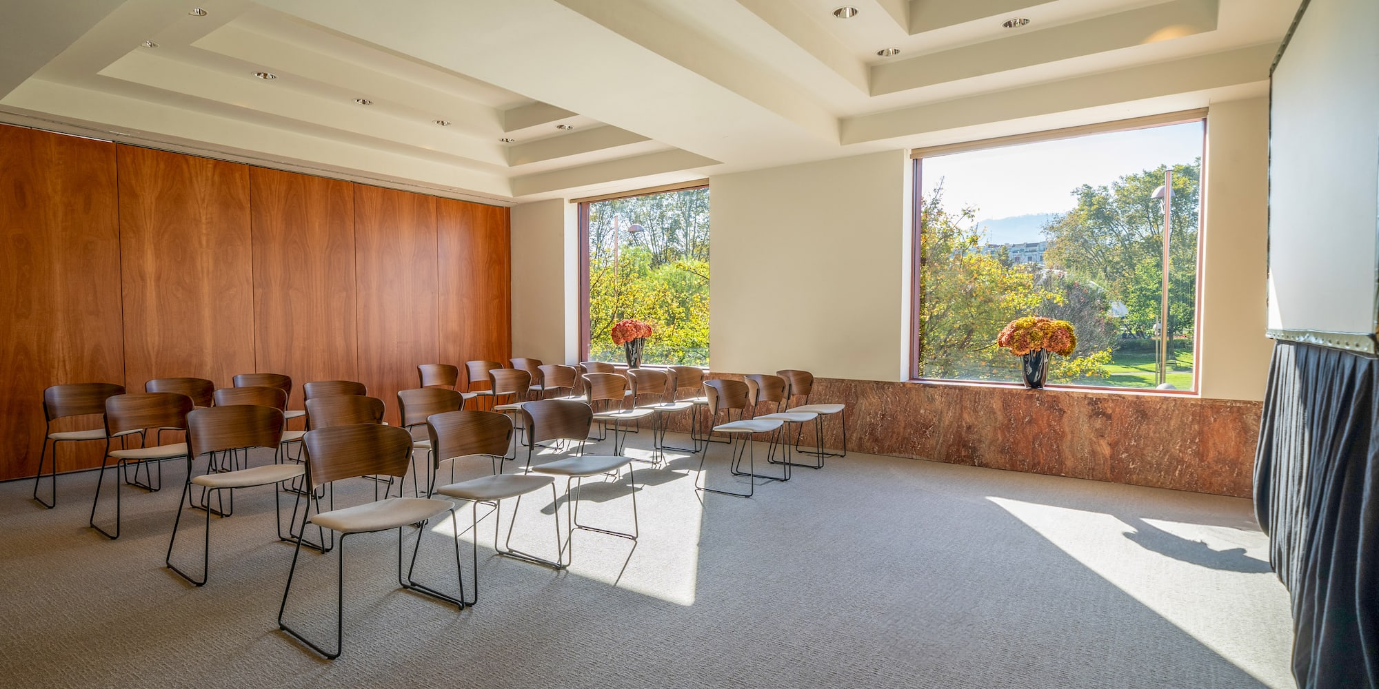 a room with chairs and a vase of flowers