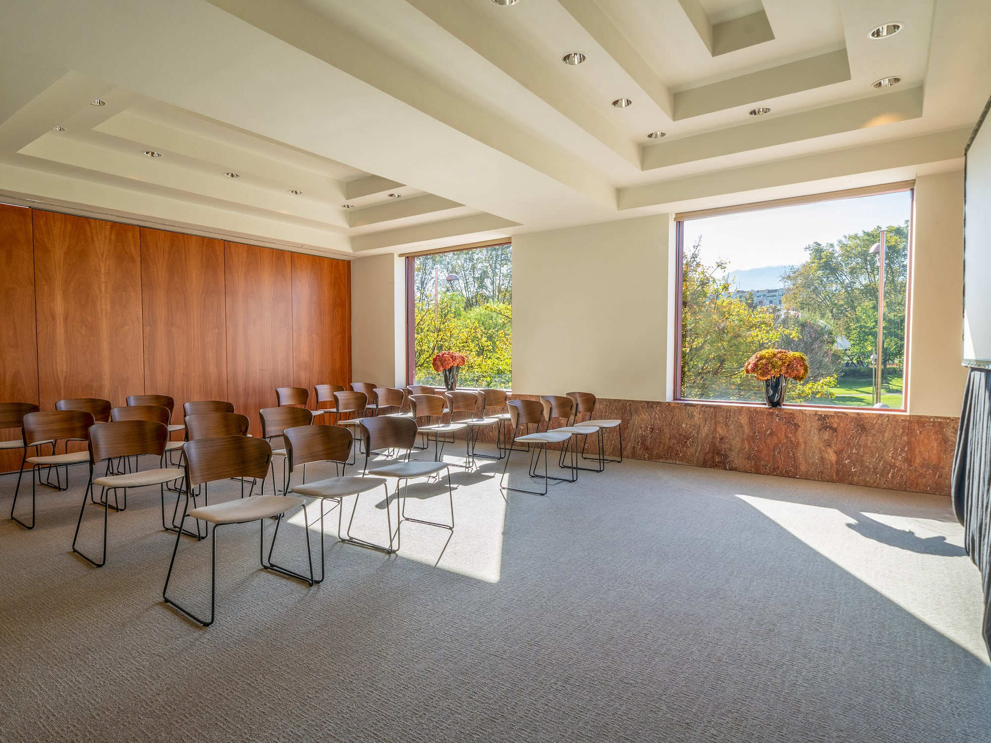 a room with chairs and a vase of flowers