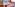 Modern hotel room with two single beds, white linen, and orange accents.