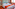 Modern hotel room with two single beds, white linen, and orange accents.