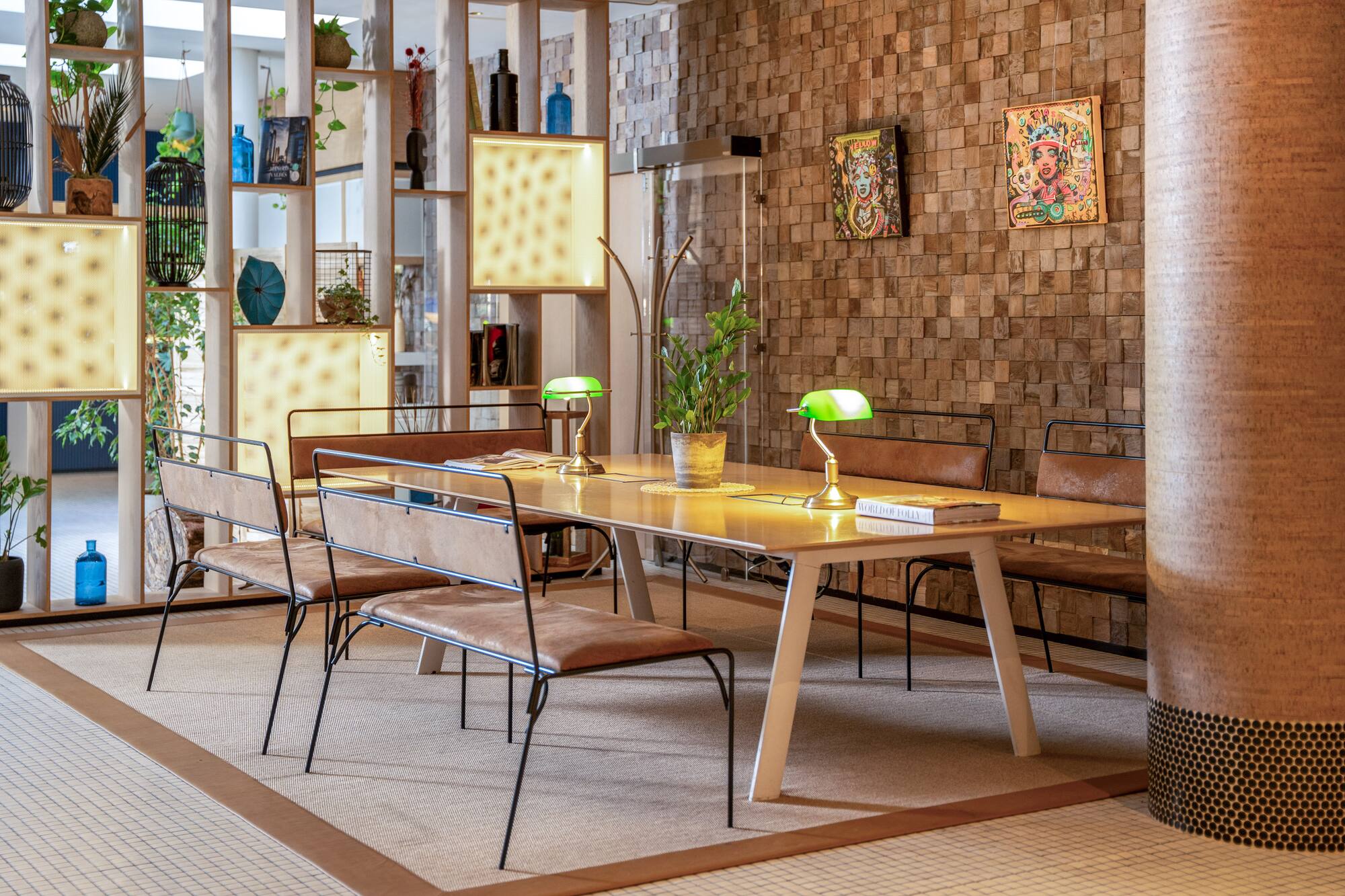Modern dining area with wooden table, leather chairs, green lamps, wood block accent wall.