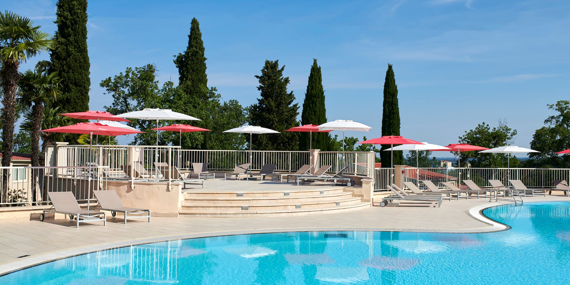 a pool with umbrellas and chairs