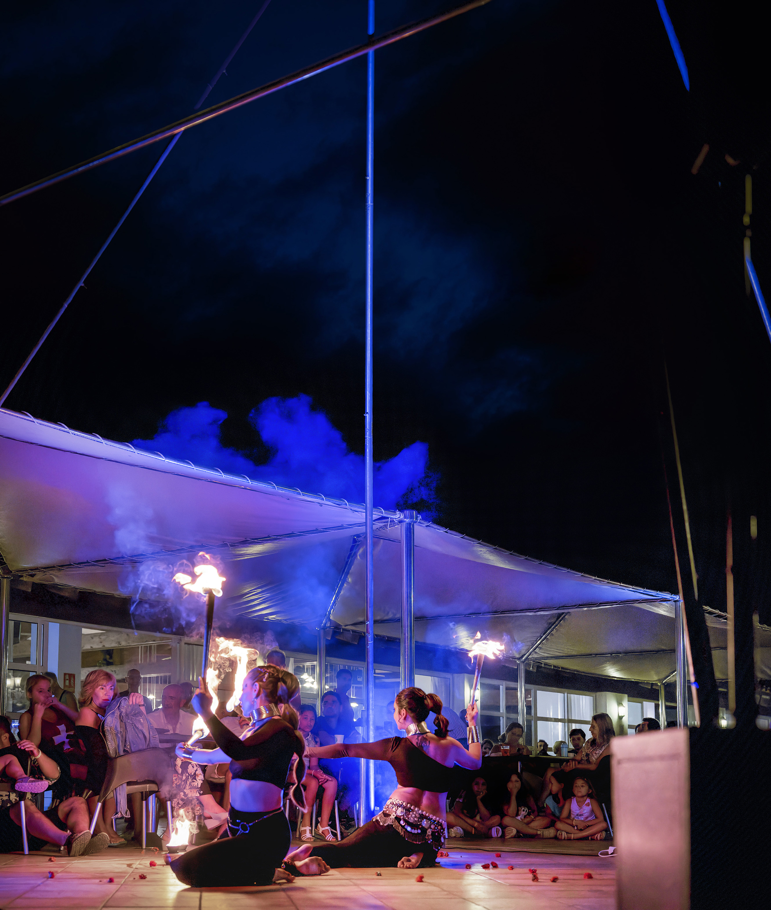 Night fire dance: two women performers with flaming torches for an audience.