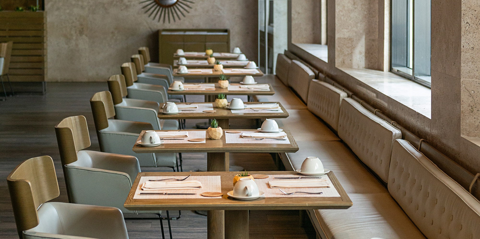 a long table with white chairs and plates on it