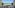 Resort balcony with sea view, wooden deck, outdoor seating, and pool.