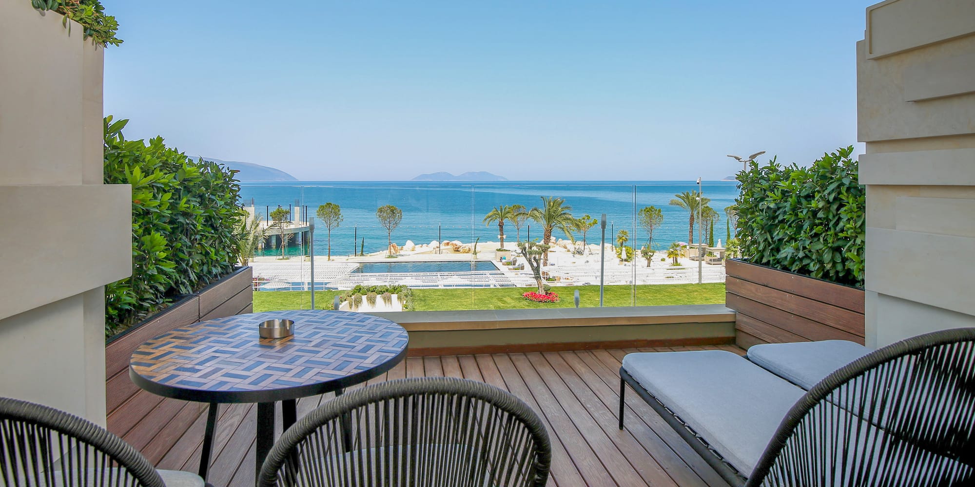 a deck with chairs and a table overlooking the ocean