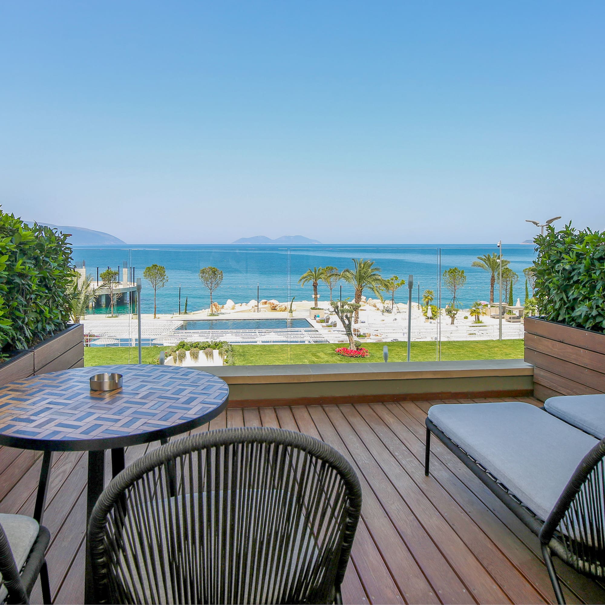 a deck with chairs and a table overlooking the ocean