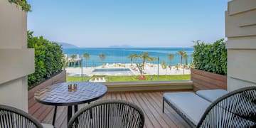 a deck with chairs and a table overlooking the ocean