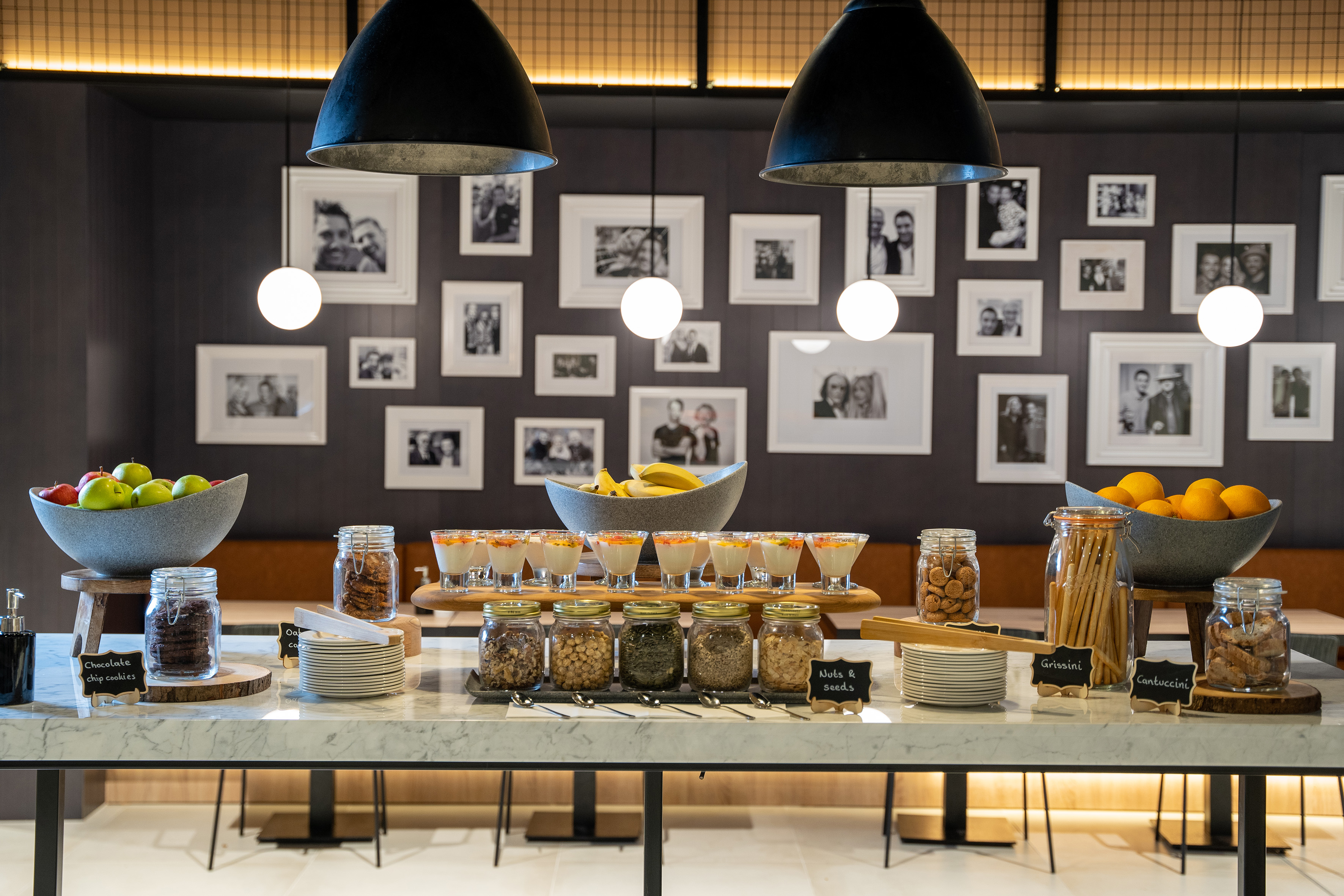 Hotel buffet with fresh fruit, yogurt parfaits, assorted cookies, and nuts.