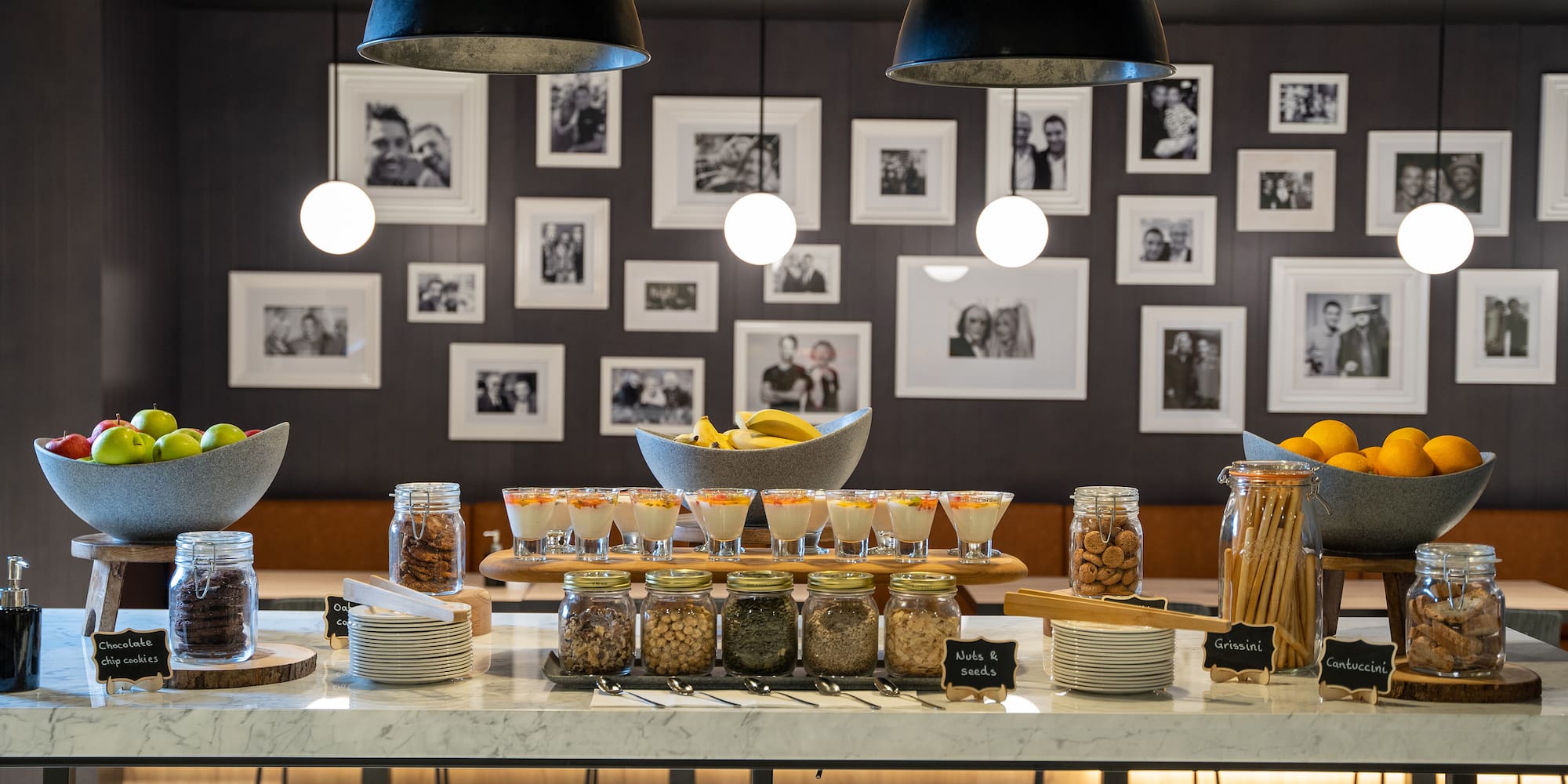 Hotel buffet with fresh fruit, yogurt parfaits, assorted cookies, and nuts.