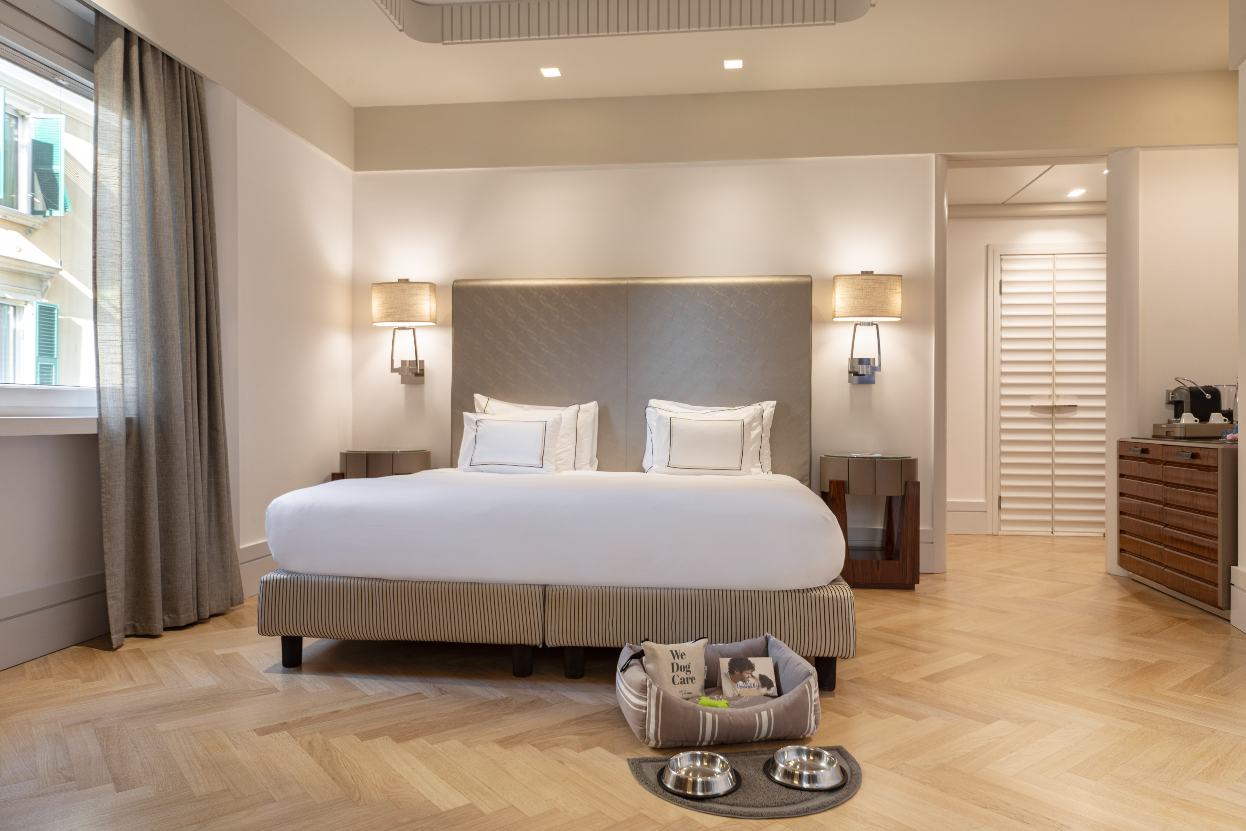 Luxury pet-friendly hotel room with large bed and dog care facilities.