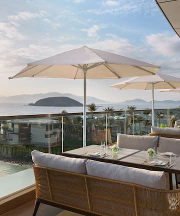 a table and chairs with umbrellas overlooking a body of water