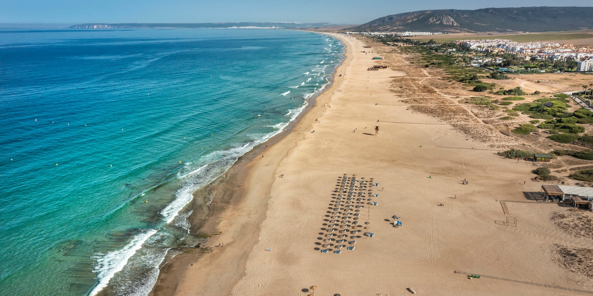 a beach with umbrellas and water
