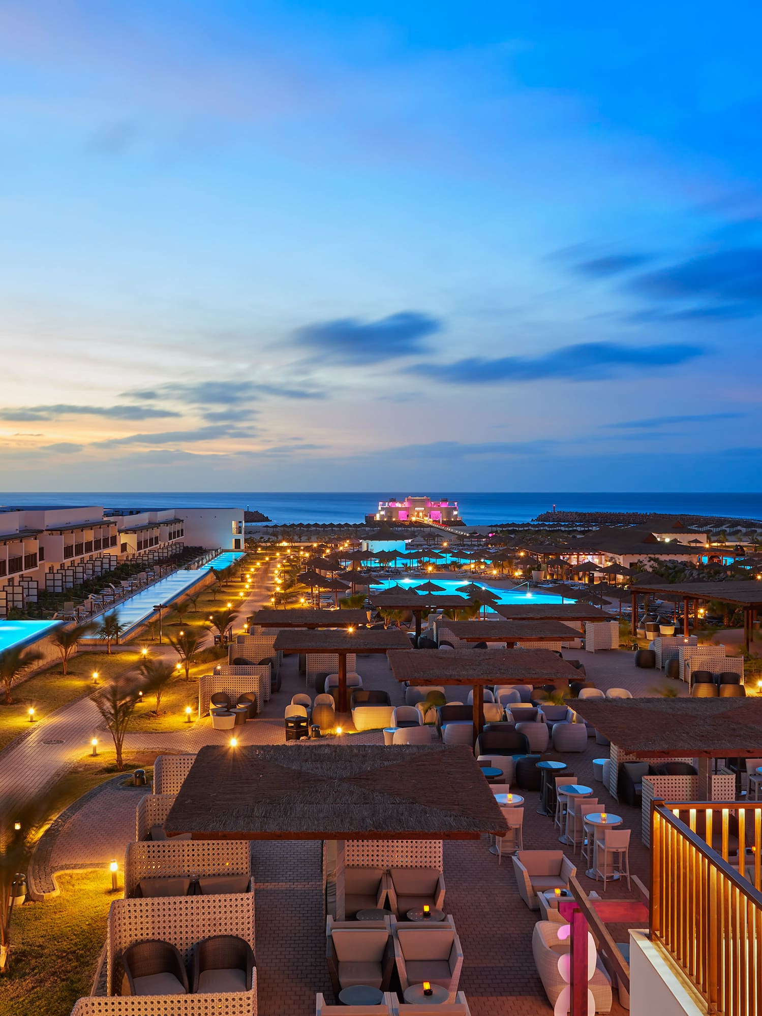a rooftops of a resort with a pool and a body of water