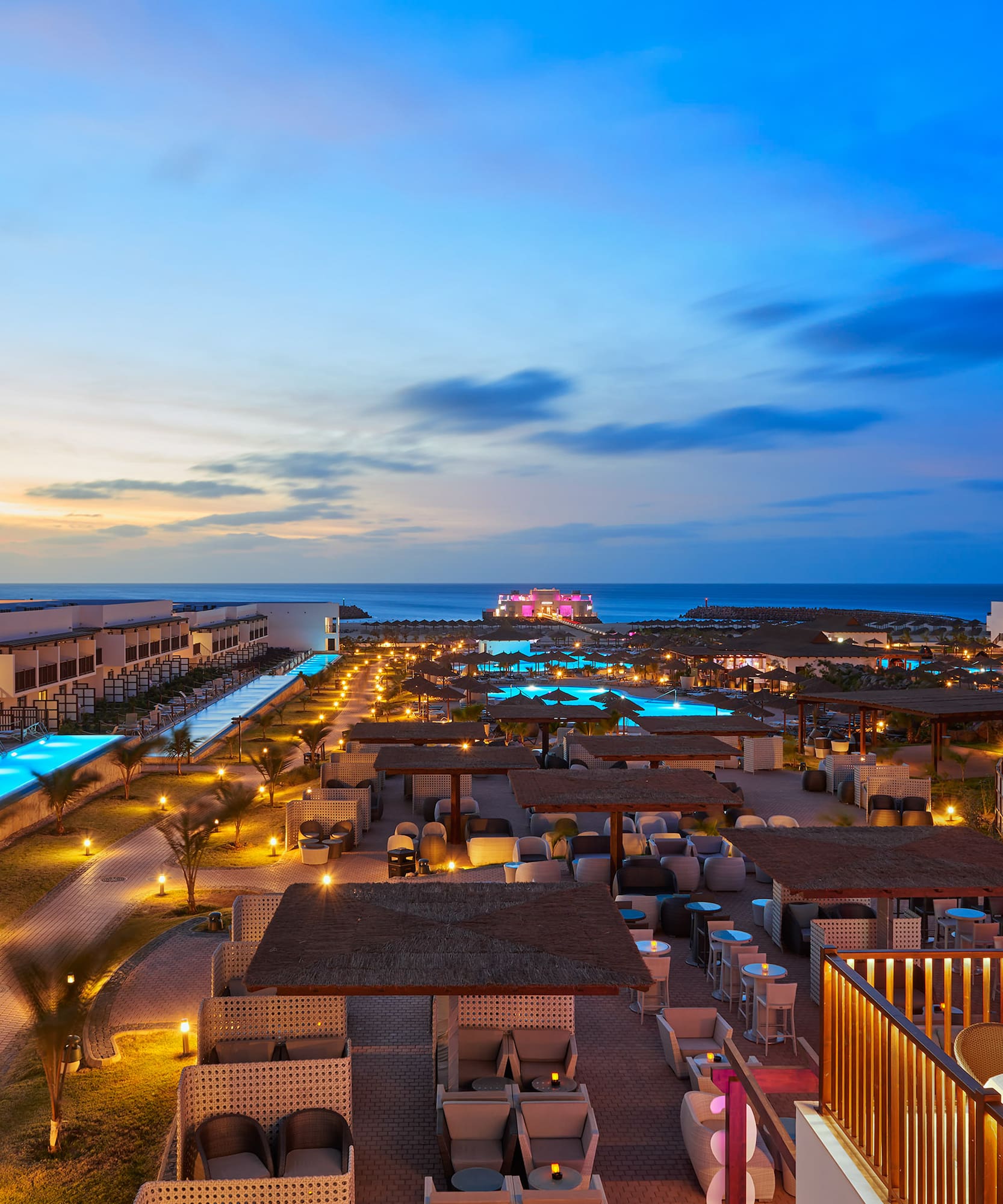 a rooftops of a resort with a pool and a body of water