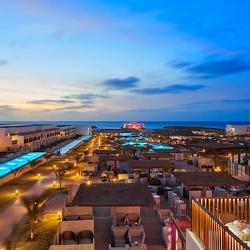 a rooftops of a resort with a pool and a body of water