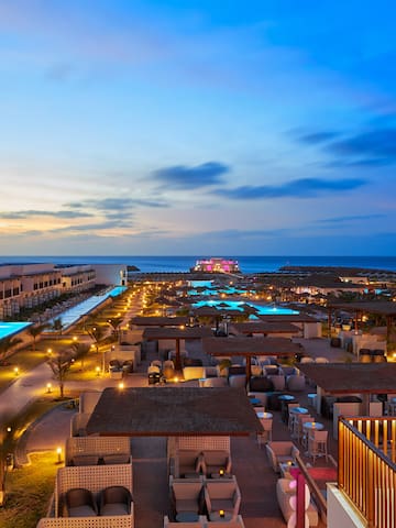 a rooftops of a resort with a pool and a body of water
