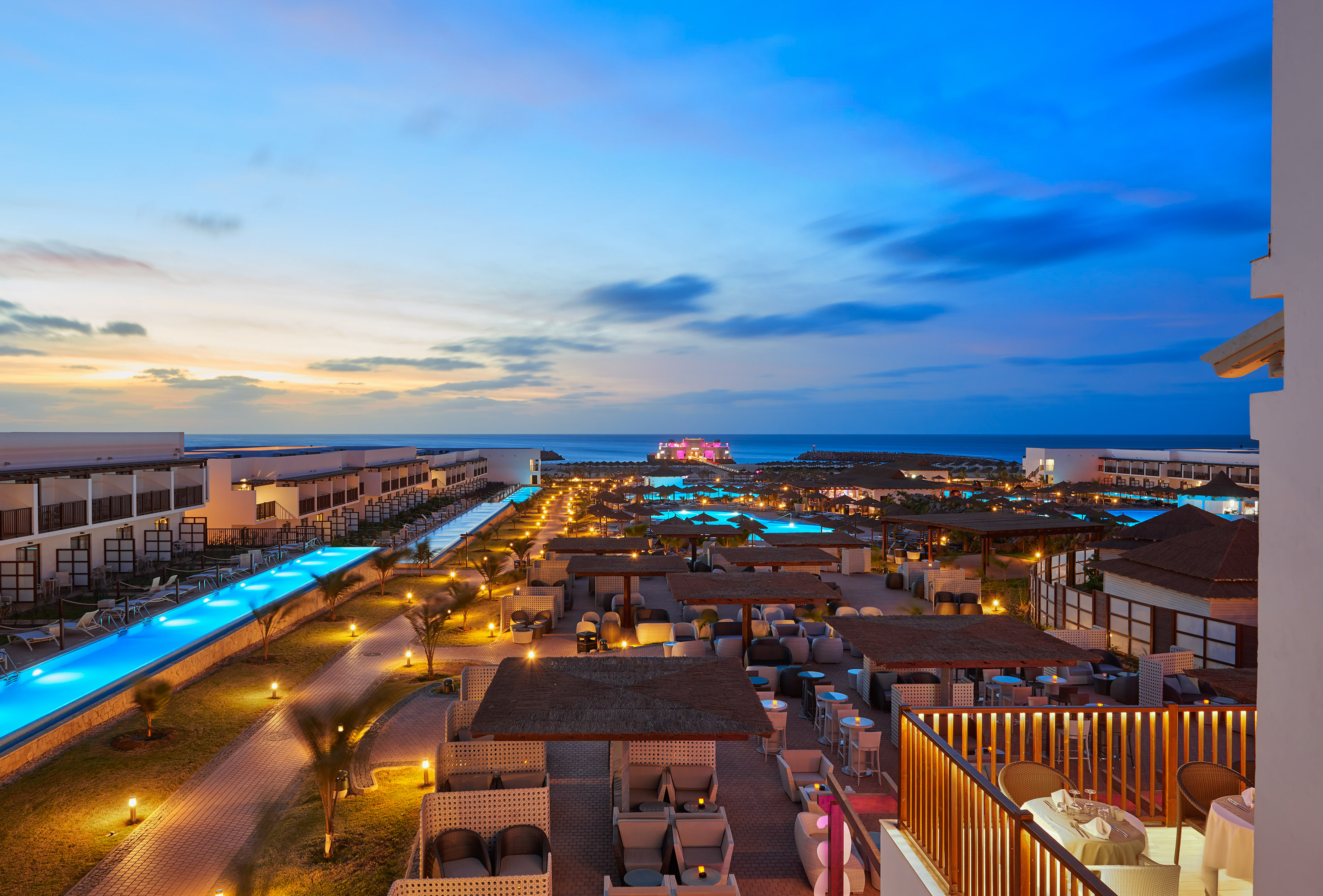 a rooftops of a resort with a pool and a body of water