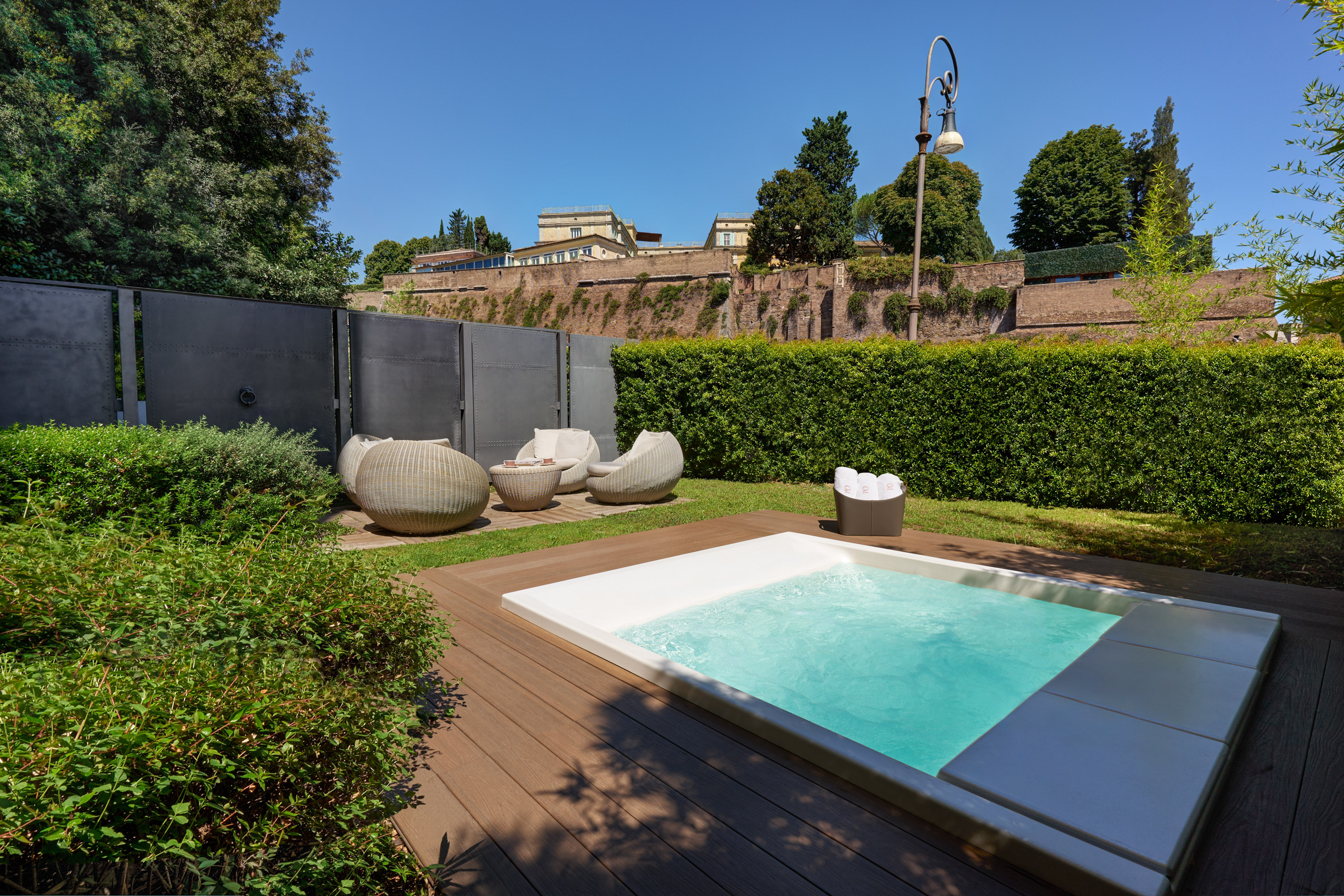 Private garden with plunge pool, wooden deck, and outdoor lounge seating.