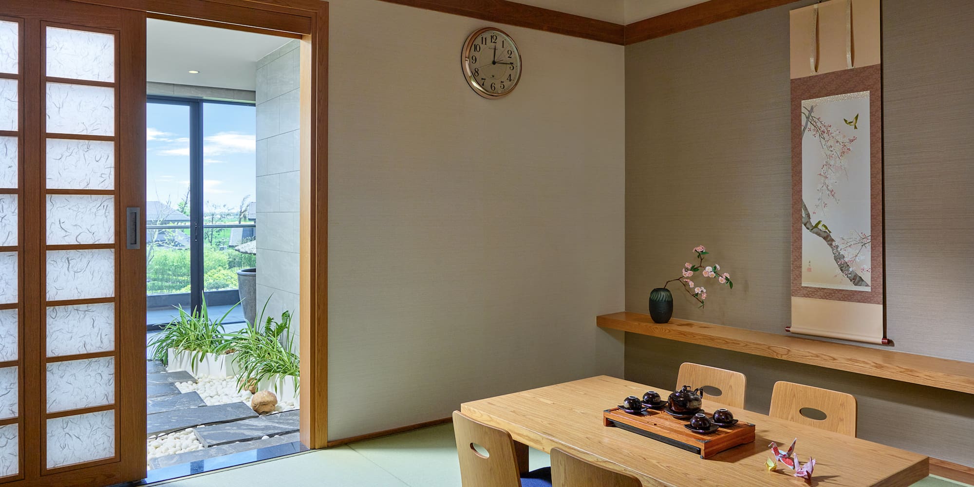 Japanese tatami room interior with wooden tea table, shoji door, and scroll art.