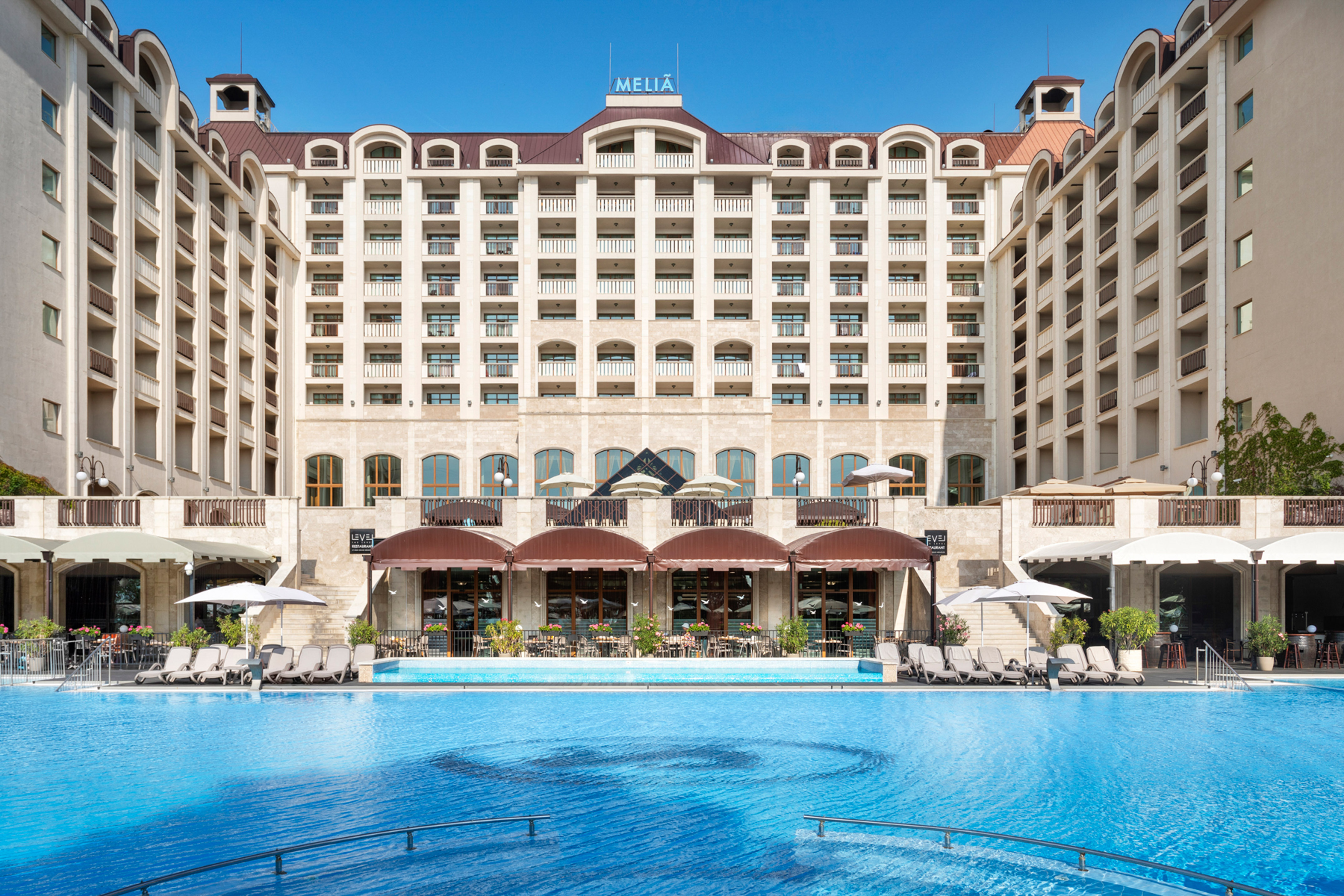 a large building with a pool in front of it