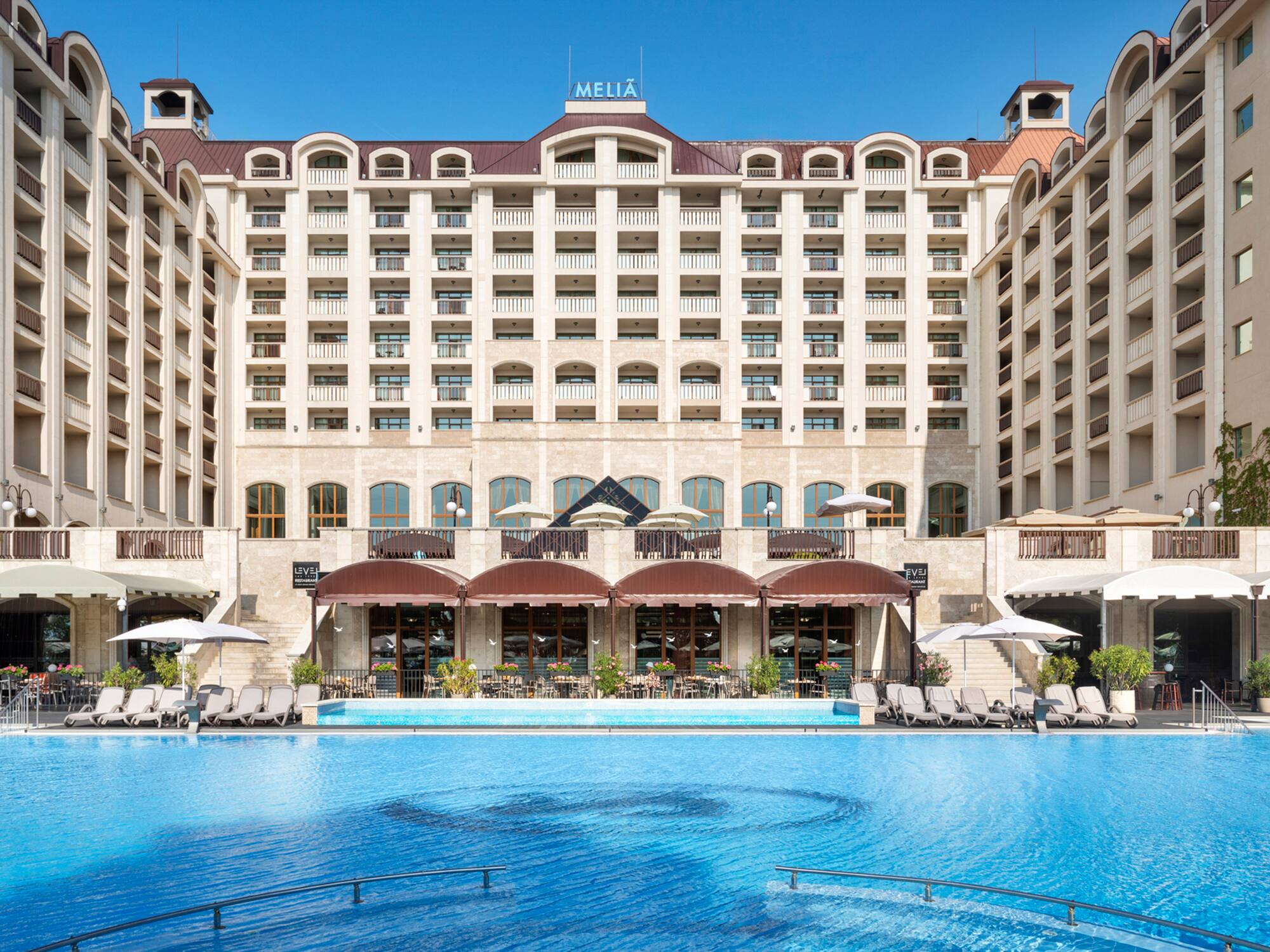 a large building with a pool in front of it