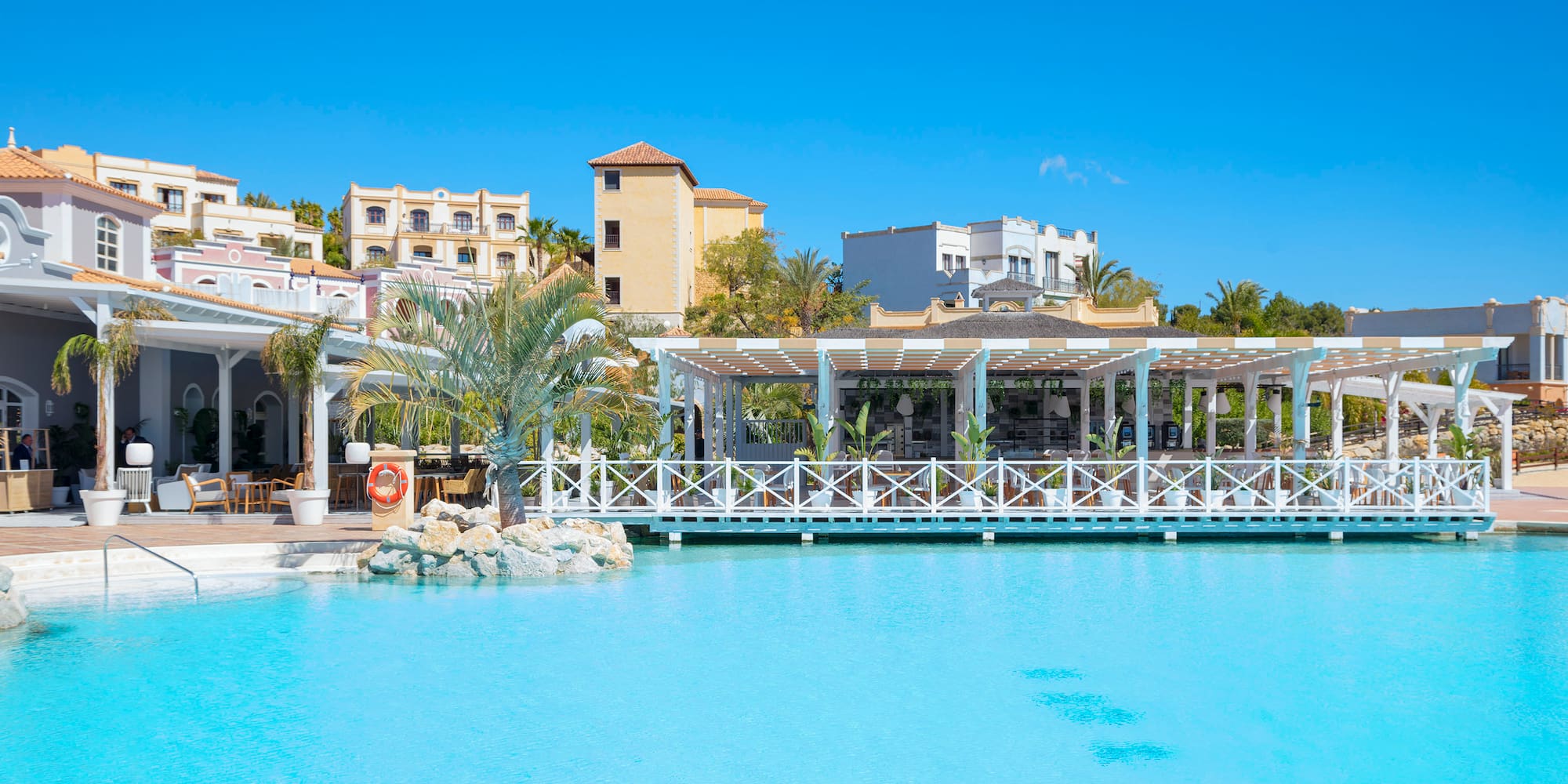 a pool with a white structure and palm trees