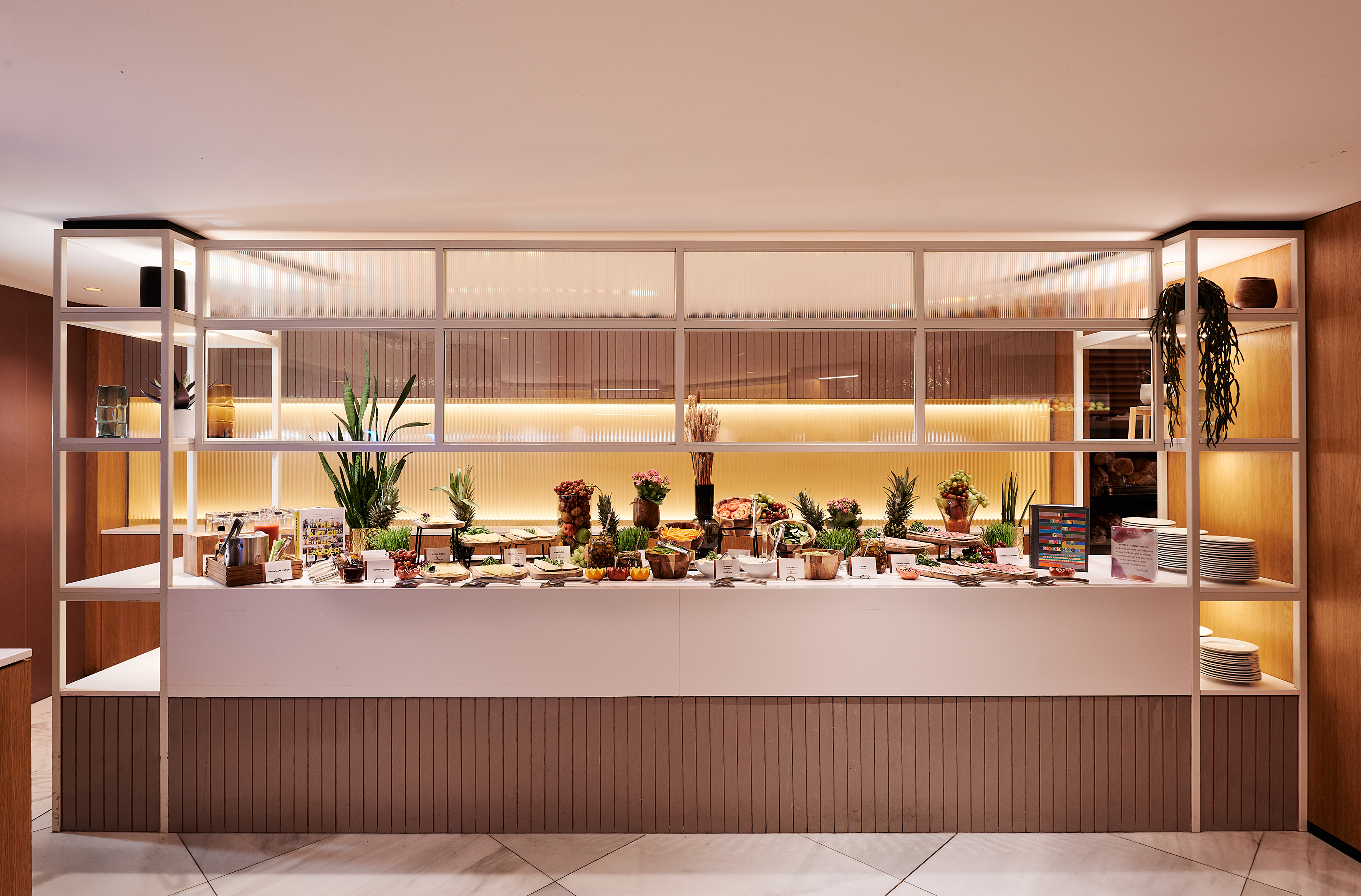 Modern hotel buffet with fresh fruits, healthy dishes, and elegant decor.