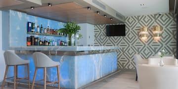 a bar with a blue counter and chairs