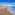 a beach with buildings and blue water