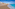 a beach with buildings and blue water